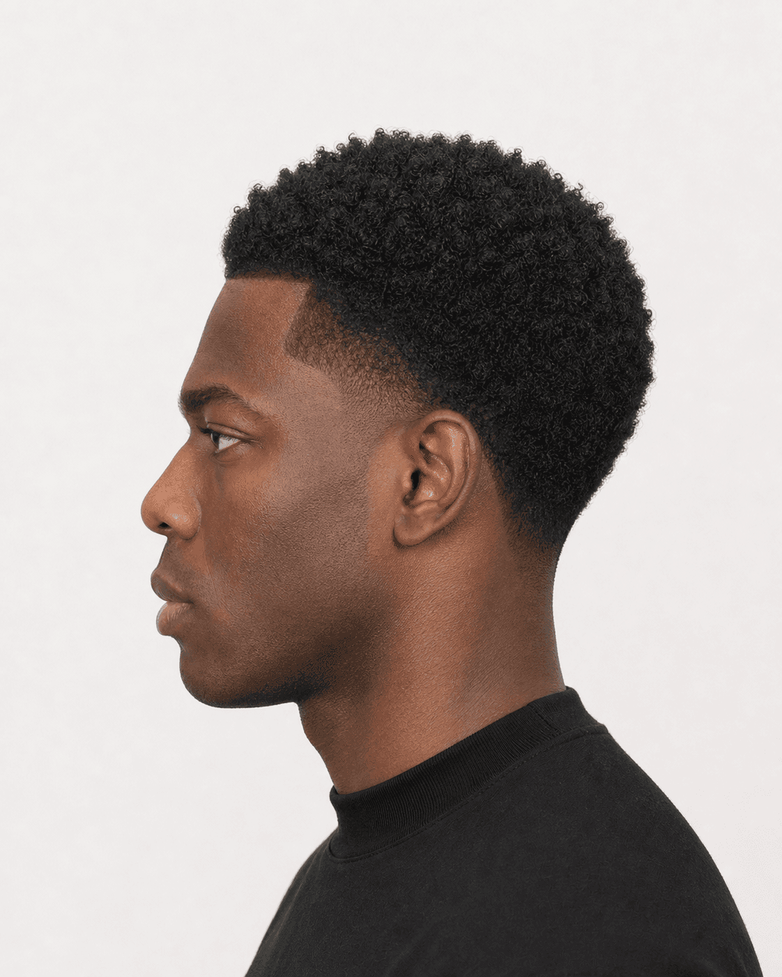 Side profile showing a short coily-looking top, retained side weight, and localized temple gradient
