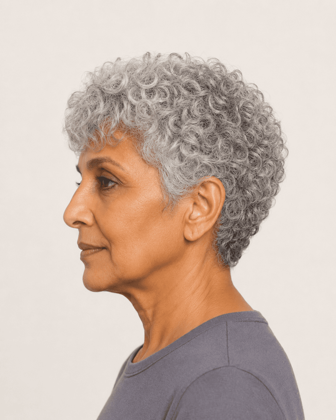 Side profile of natural silver curls showing the tapered side and cropped nape