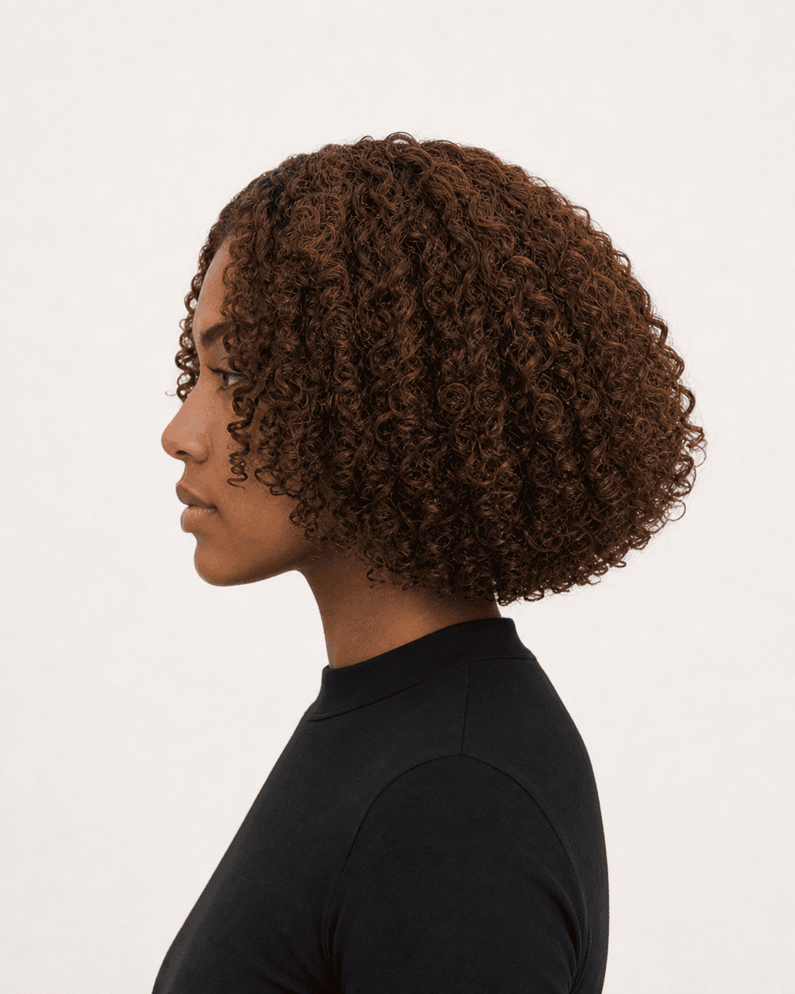 Annotated side construction map for Rounded Curly Bob. Side profile of a rounded curly bob showing crown lift and upper-neck perimeter